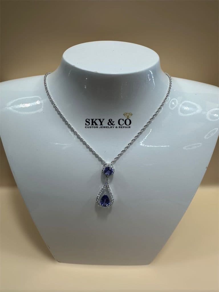 A custom sapphire and diamond drop necklace on a bust