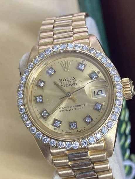 A gold Rolex Datejust with a diamond bezel